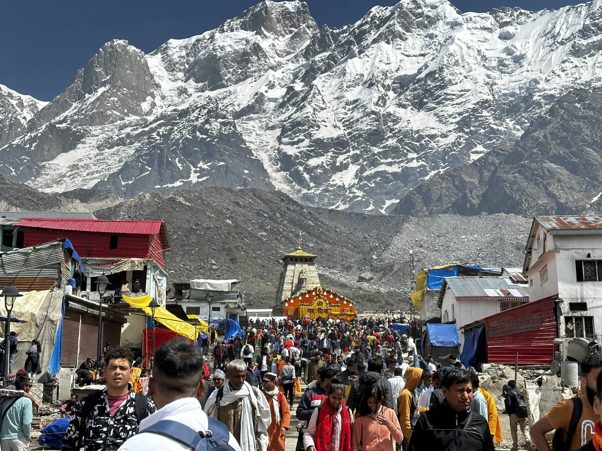 Kedarnath Dham and pilgrims below the snow peaks